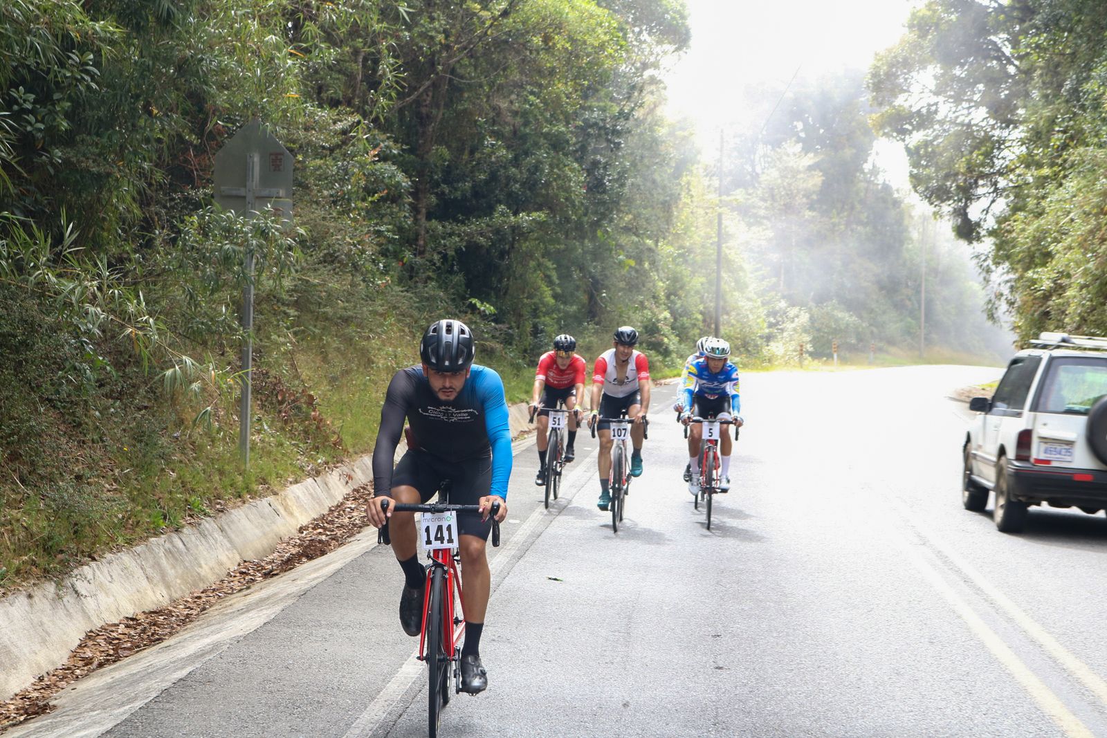 Grupo de ciclistas subiendo entre la neblina del Cerro de La Muerte